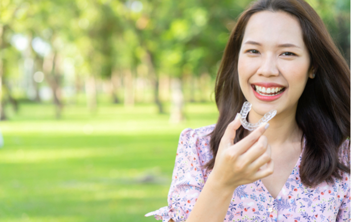 woman smiling while wearing invisalign invisible braces for straighter teeth