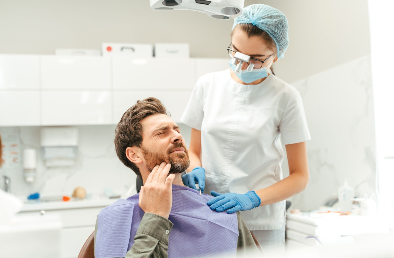 A dentist prepares their patient with tooth pain for their root canal.