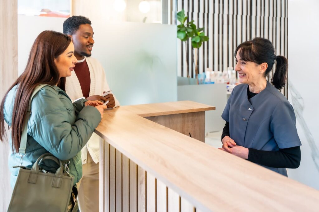 A receptionist goes over an estimate for a patient's dental cleaning cost.