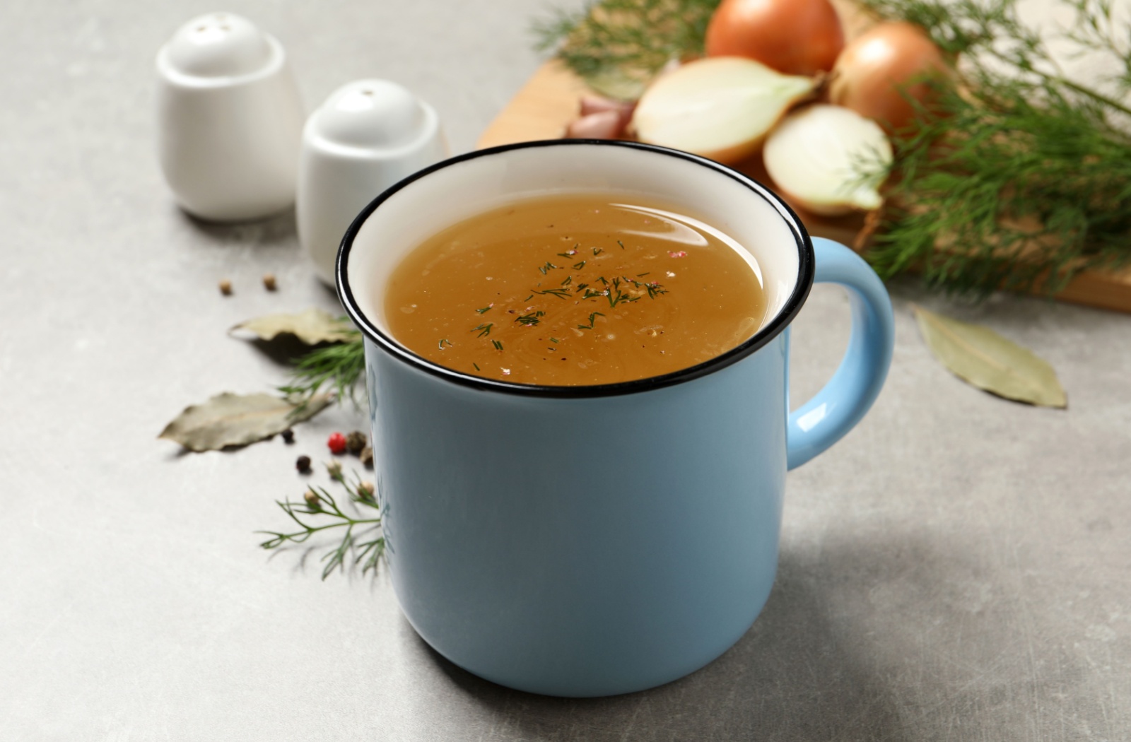 Cup of warm broth representing a soft food option after dental extraction.